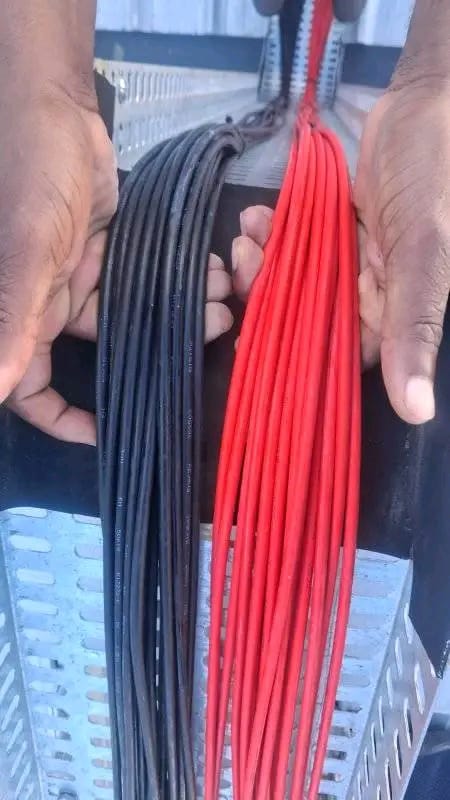 Red and black solar DC cable runs prepared on a cable tray