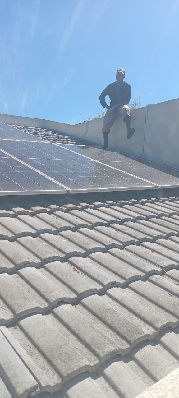 Deltar Electrical team member installing solar panels on a roof